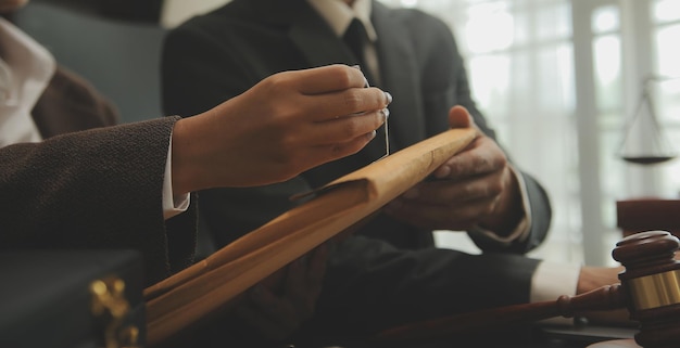 Martelo de juiz com advogados de Justiça tendo reunião de equipe no fundo do escritório de advocacia Conceitos de Direito e Serviços Jurídicos