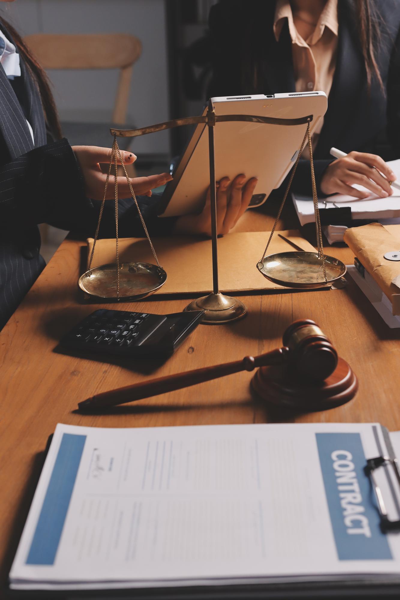 Jovem advogada atraente no escritório Mulher de negócios e advogados discutindo papéis de contrato com balança de latão em uma mesa de madeira no escritório Serviços jurídicos de direito Conselhos de justiça e conceito imobiliário
